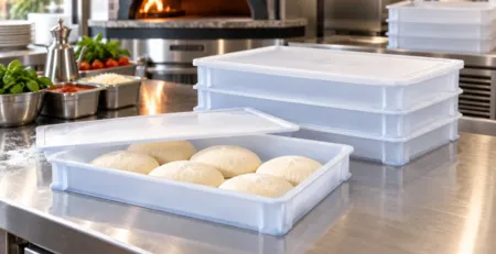 Cutii pentru aluat de pizza stivuite într-o zonă de preparare