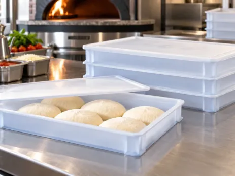 Cutii pentru aluat de pizza stivuite într-o zonă de preparare